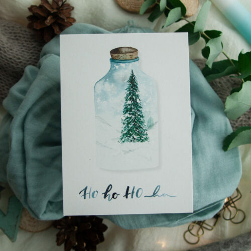 Weihnachtspostkarte „HO HO HO“ zeigt eine handgezeichnete Illustration eines festlichen Tannenbaums in einer Glasflasche, umgeben von einer winterlichen Schneelandschaft. Gestaltet von Frau Feierlich