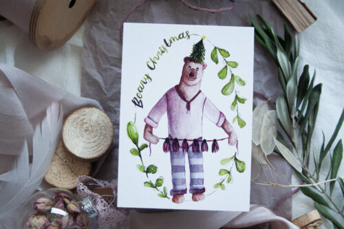 Weihnachts-Postkarte "Beary Christmas" – handgezeichneter Bär mit Weihnachtsdeko, humorvolle Grußkarte auf Recyclingpapier im A6-Format. Perfekt für nachhaltige Weihnachtsgrüße.